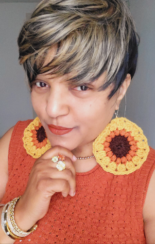 Black woman wearing oversized crocheted sunflower earrings