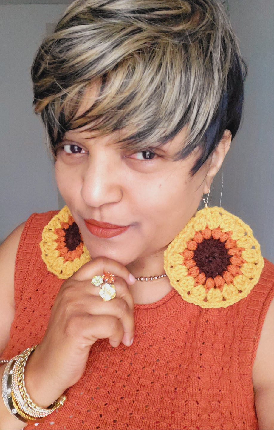 Black woman wearing oversized crocheted sunflower earrings